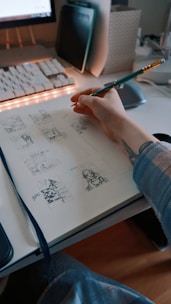 a person sitting at a desk with a pen in their hand