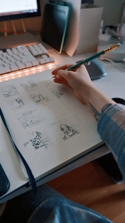 a person sitting at a desk with a pen in their hand