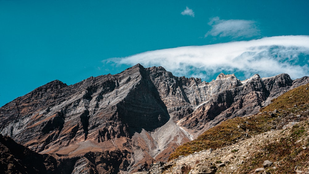 a very tall mountain with some clouds in the sky