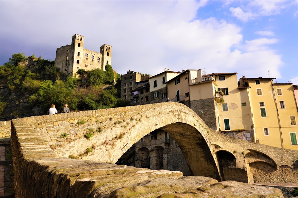 a stone bridge over a river with a castle in the background