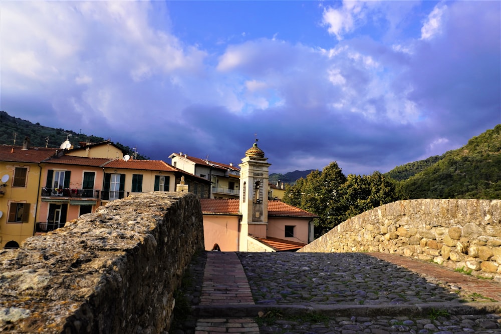 a stone wall with a clock tower in the background