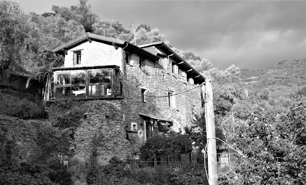 a black and white photo of a house on a hill