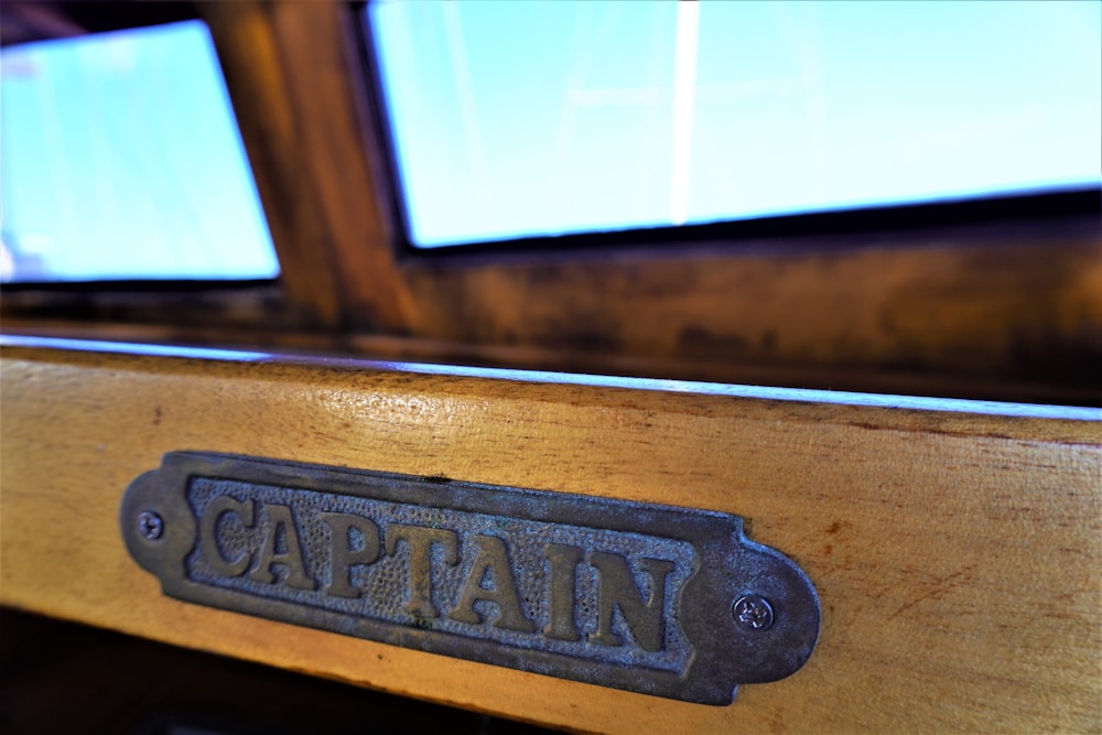 a close up of a wooden table with a metal name plate