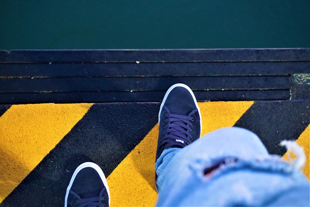 a person standing on a yellow and black striped floor