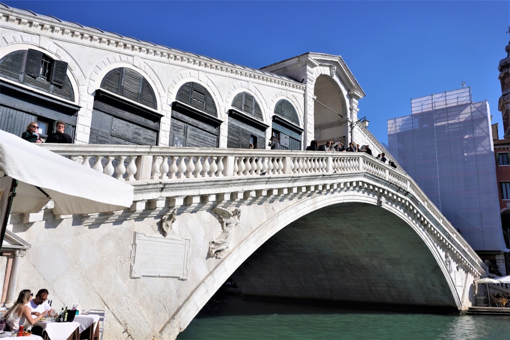 a bridge over a body of water with people sitting on it