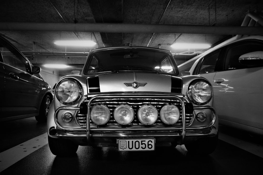 a black and white photo of a car in a parking garage