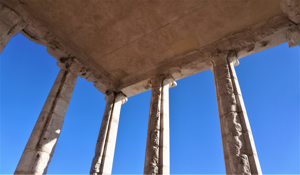 a group of pillars with a blue sky in the background