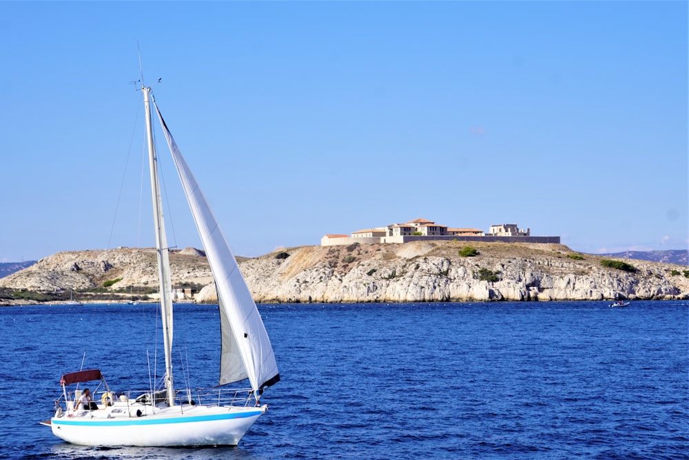 a sailboat in the water with a castle in the background