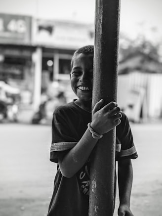 a young boy is holding on to a pole