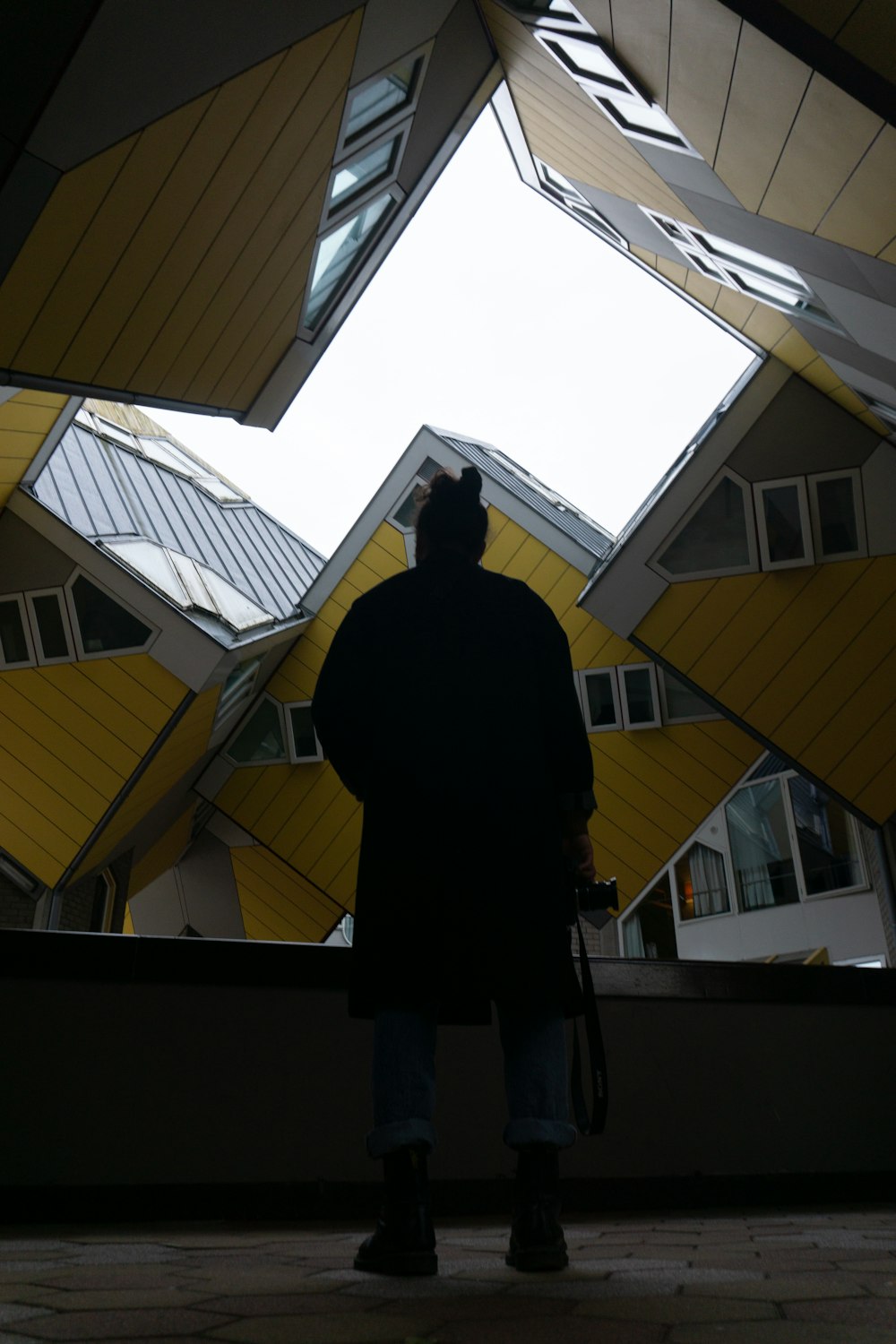 uma pessoa em pé na frente de um edifício com uma claraboia