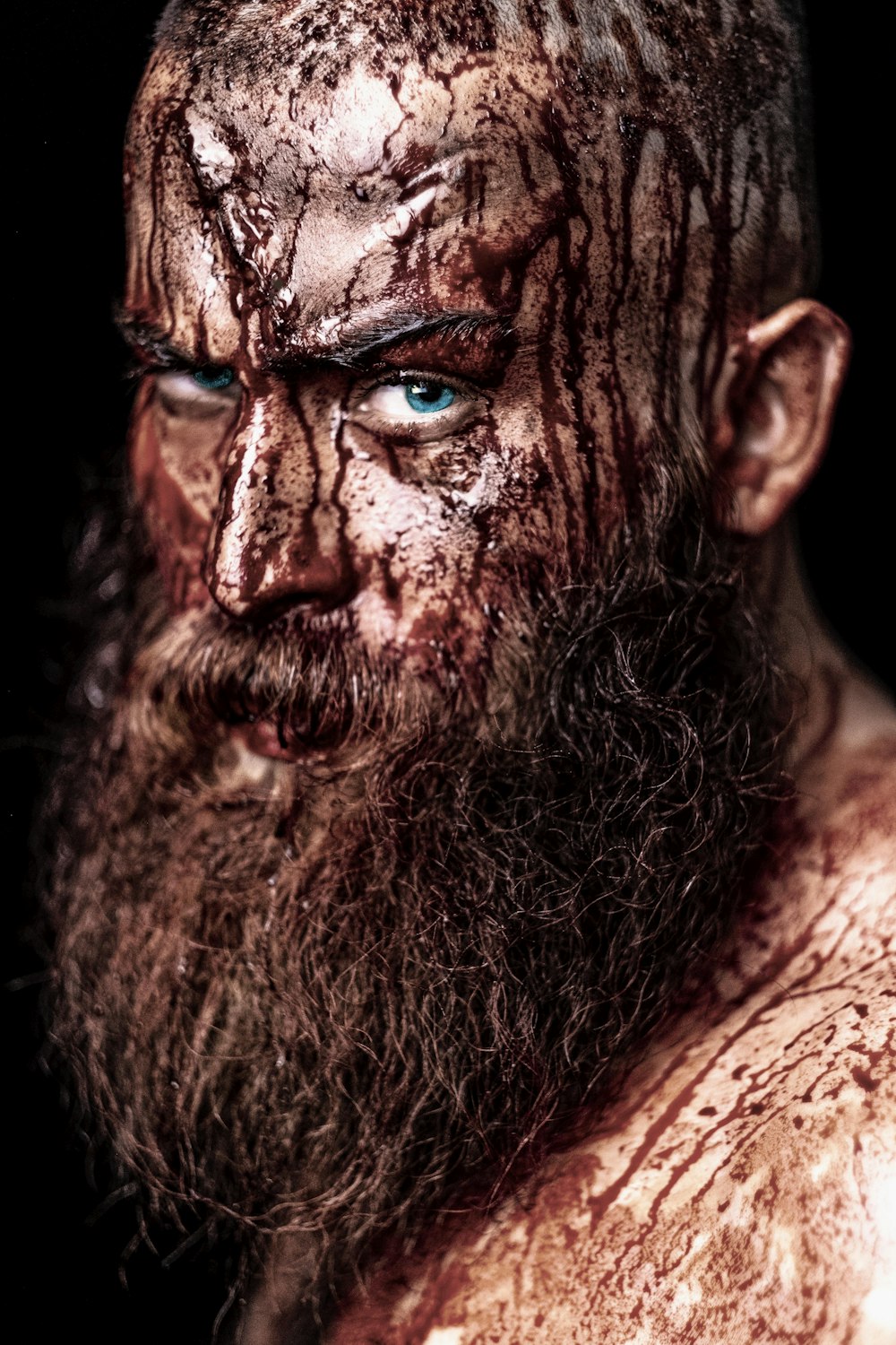 a close up of a man with a beard and blue eyes