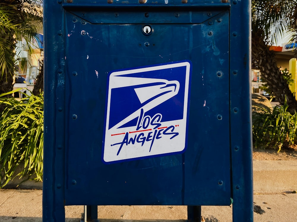 une boîte aux lettres bleue avec un autocollant d’avion dessus