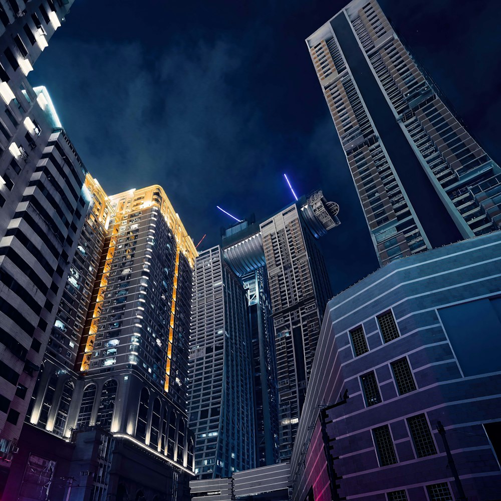 a group of tall buildings lit up at night