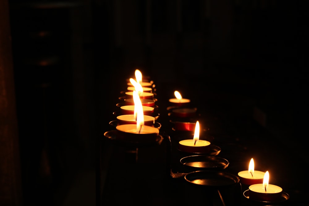 a row of lit candles in a dark room
