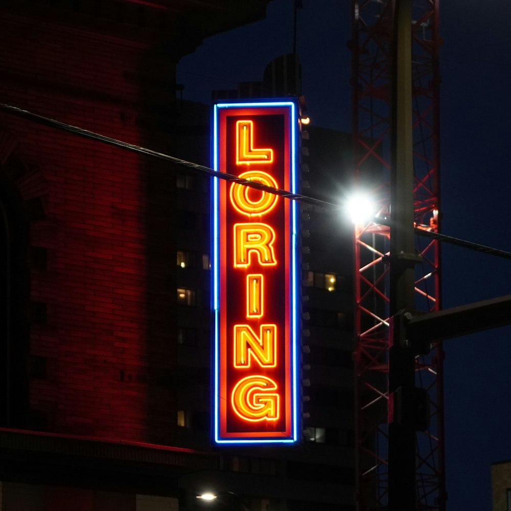 a neon sign is lit up on the side of a building