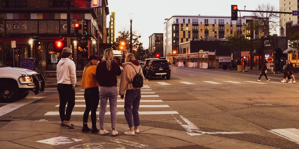 a group of people standing on the side of a road