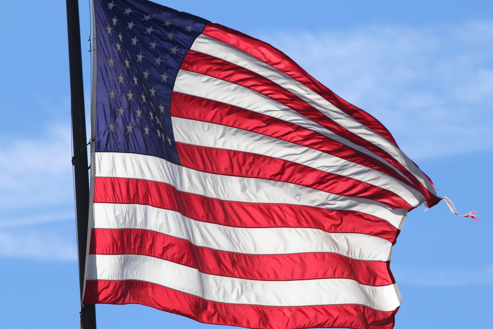 a large american flag flying in the wind