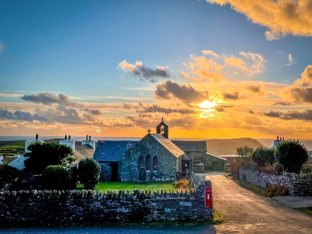 the sun is setting over a small village