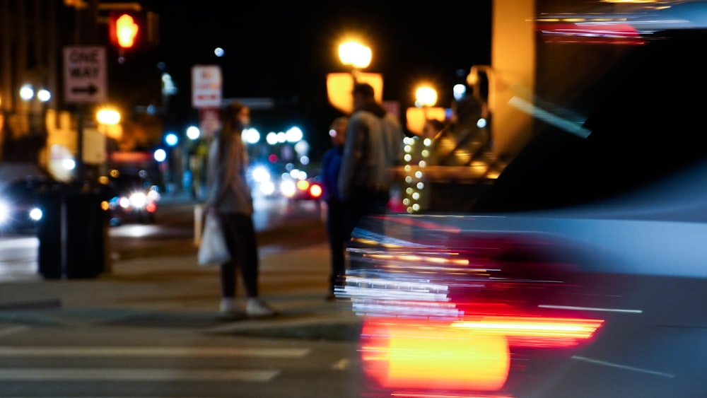 a blurry photo of a person crossing a street at night