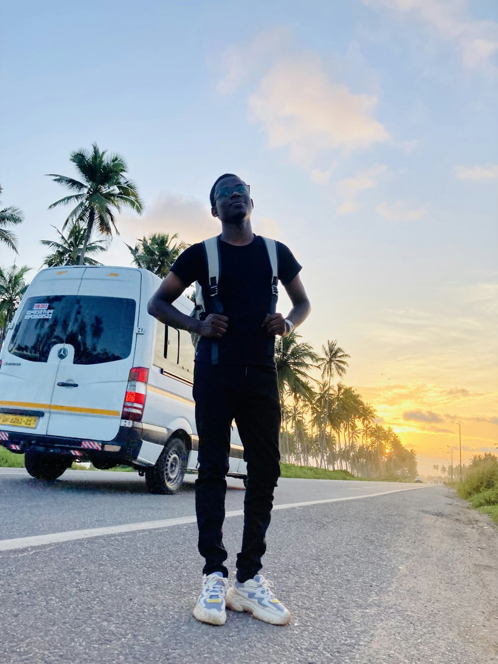 a man standing on the side of a road next to a van