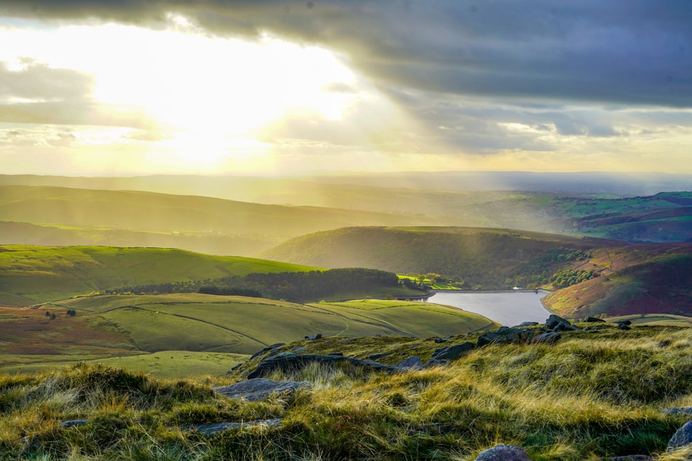 the sun shines through the clouds over a valley