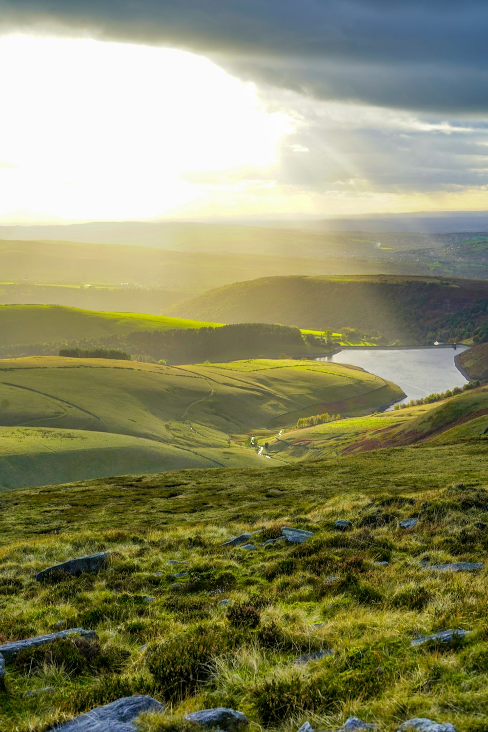 the sun shines through the clouds over a valley