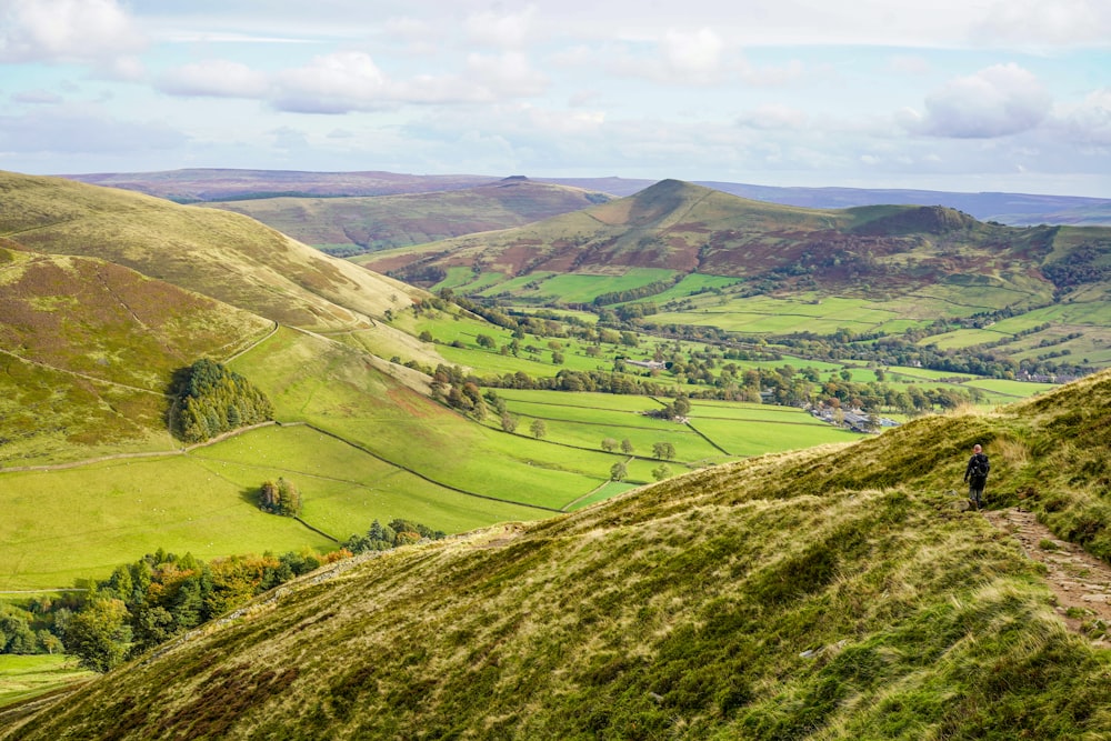 a person standing on top of a lush green hillside