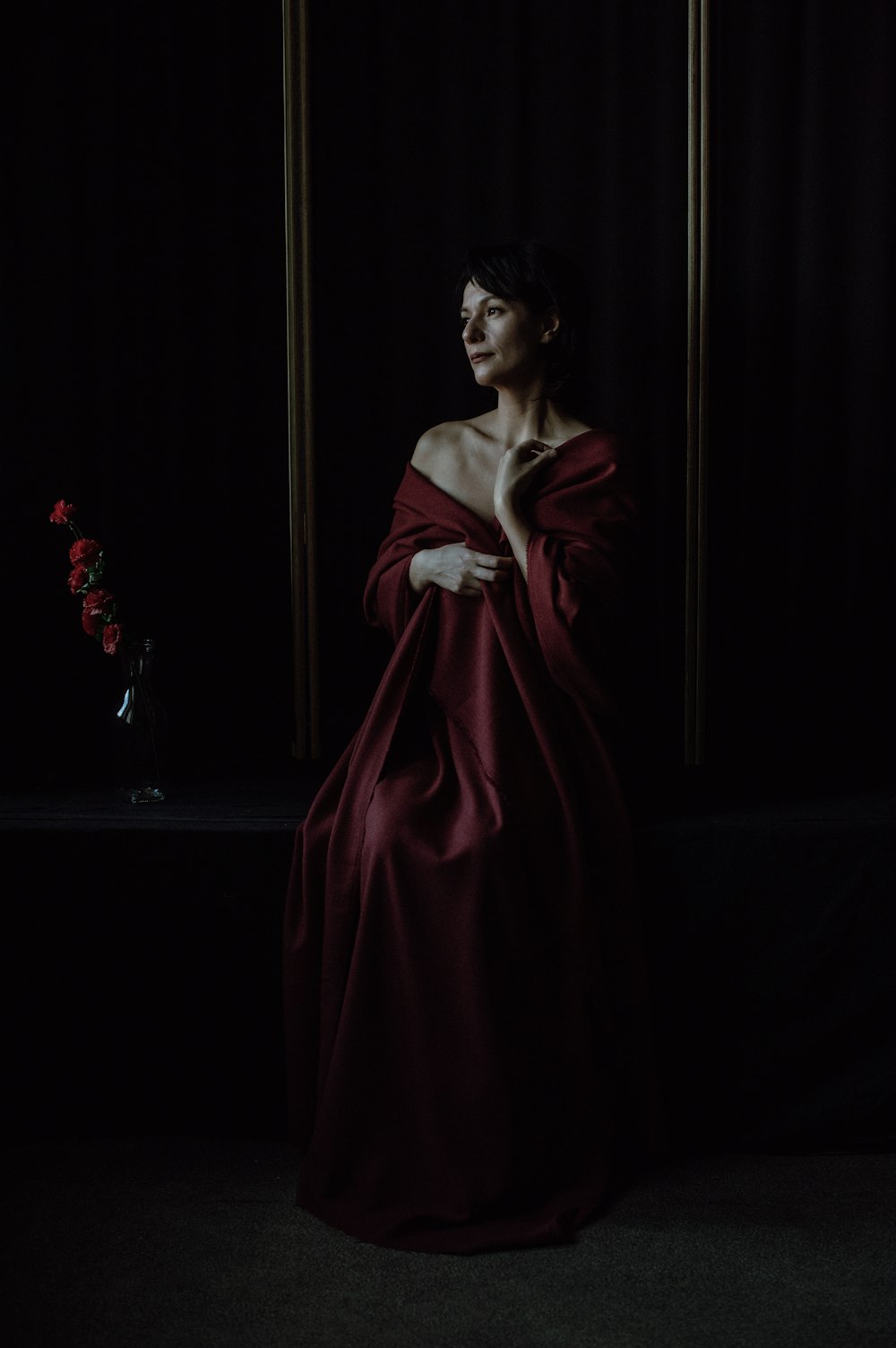 a woman in a red dress standing in a dark room