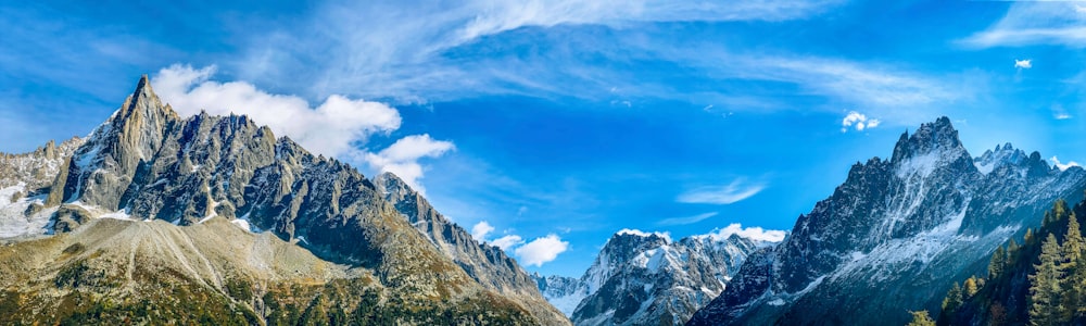 a mountain range with a blue sky and clouds