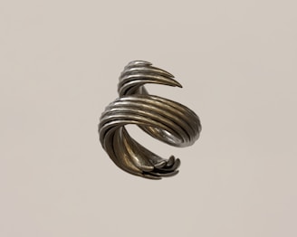Close-up of a matte-finished helix sculpture floating on a clean white background, highlighted by gentle fade-in animation.