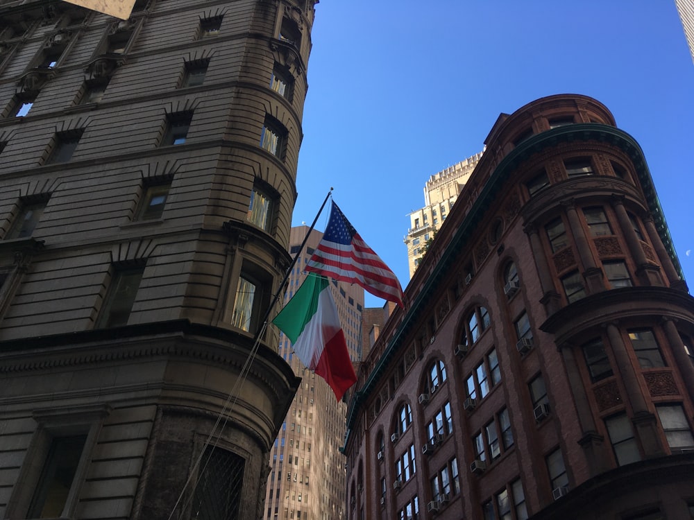 two flags are flying in front of a building