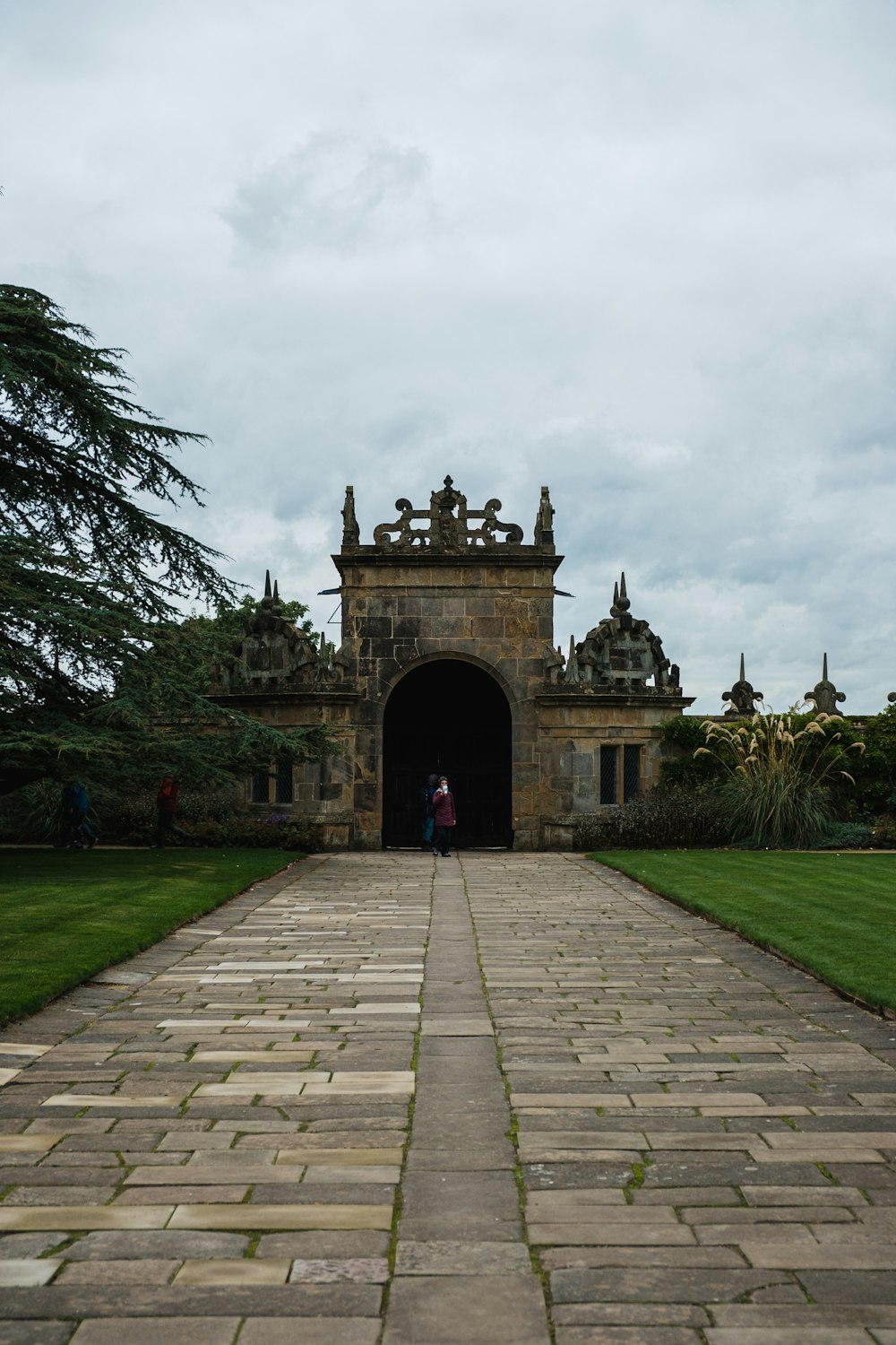 a person standing in front of a stone entrance