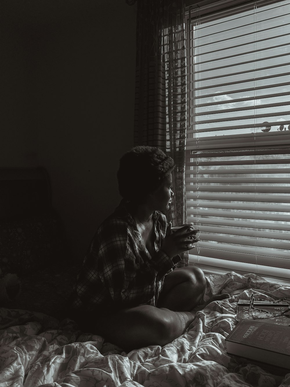 a woman sitting on a bed looking at her cell phone