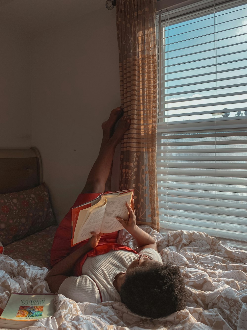 a person laying on a bed reading a book