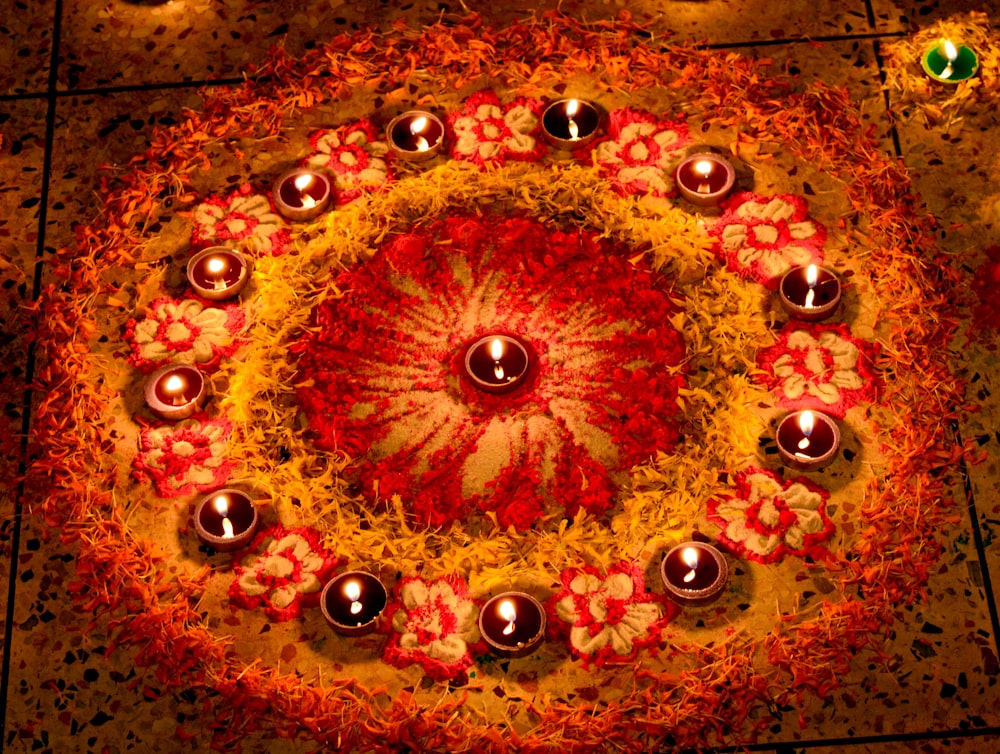 eine kreisförmige Anordnung von Kerzen auf einem Boden