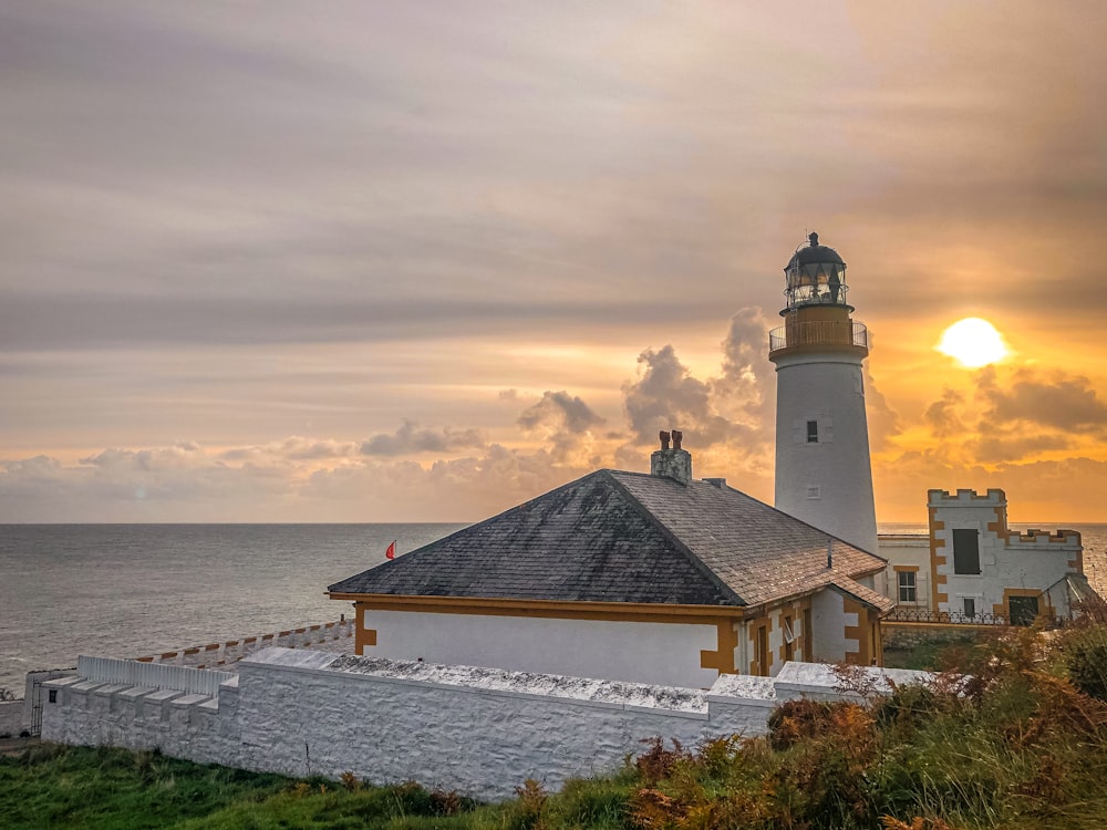 a light house sitting on top of a lush green hillside