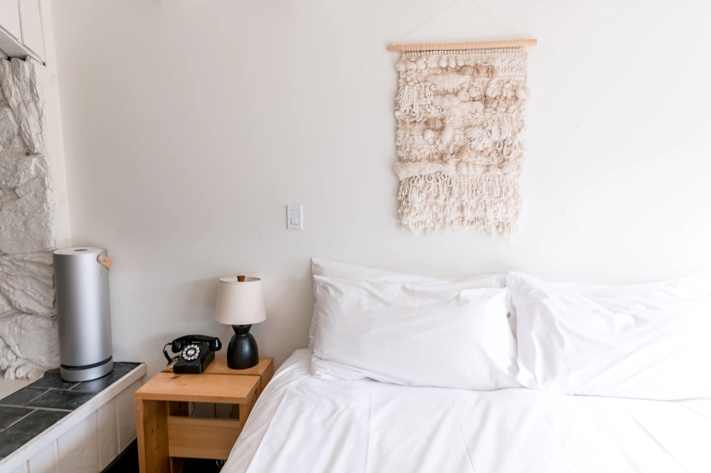 A light-filled boutique guestroom with white bedding in Catskill, New York.