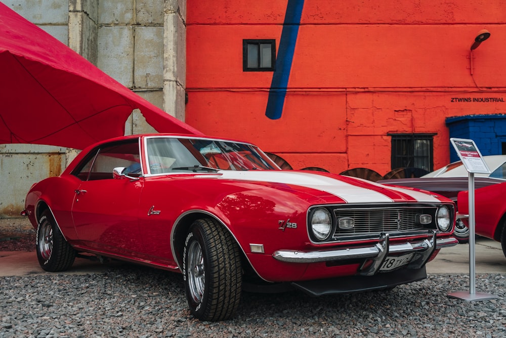 a red and white car parked next to a red building