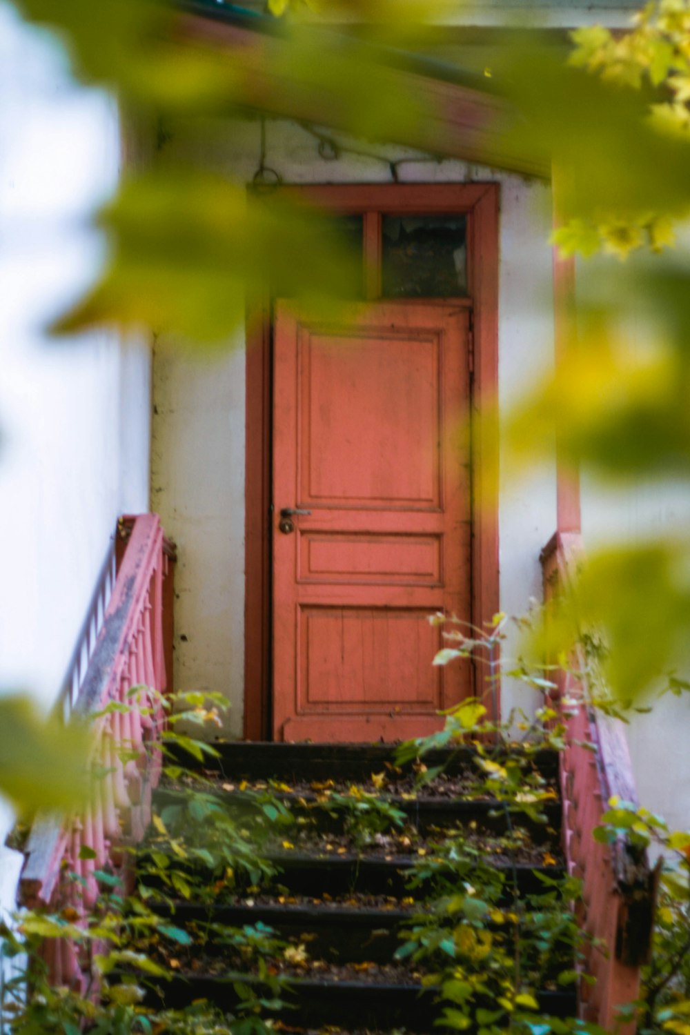 a red door sitting next to a set of stairs