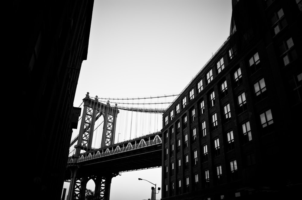 a black and white photo of a bridge and buildings
