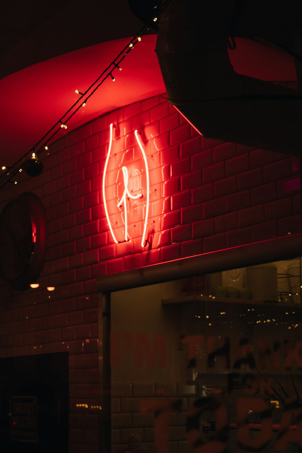 a red neon sign hanging from the side of a building