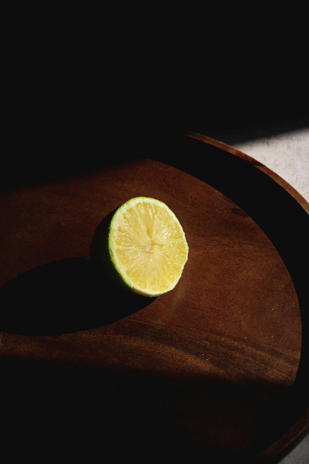 a slice of lime sitting on top of a wooden cutting board
