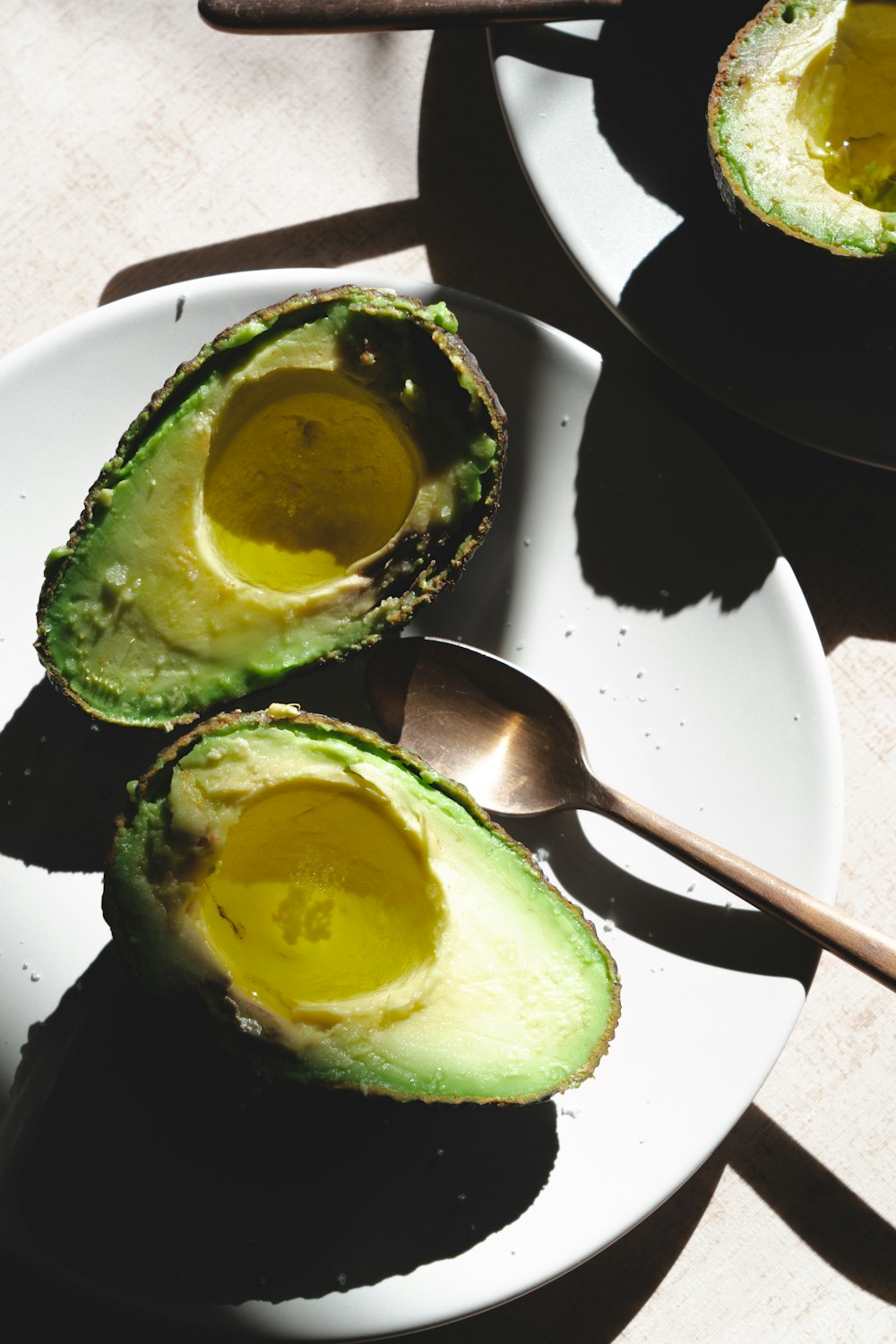 a white plate topped with an avocado cut in half