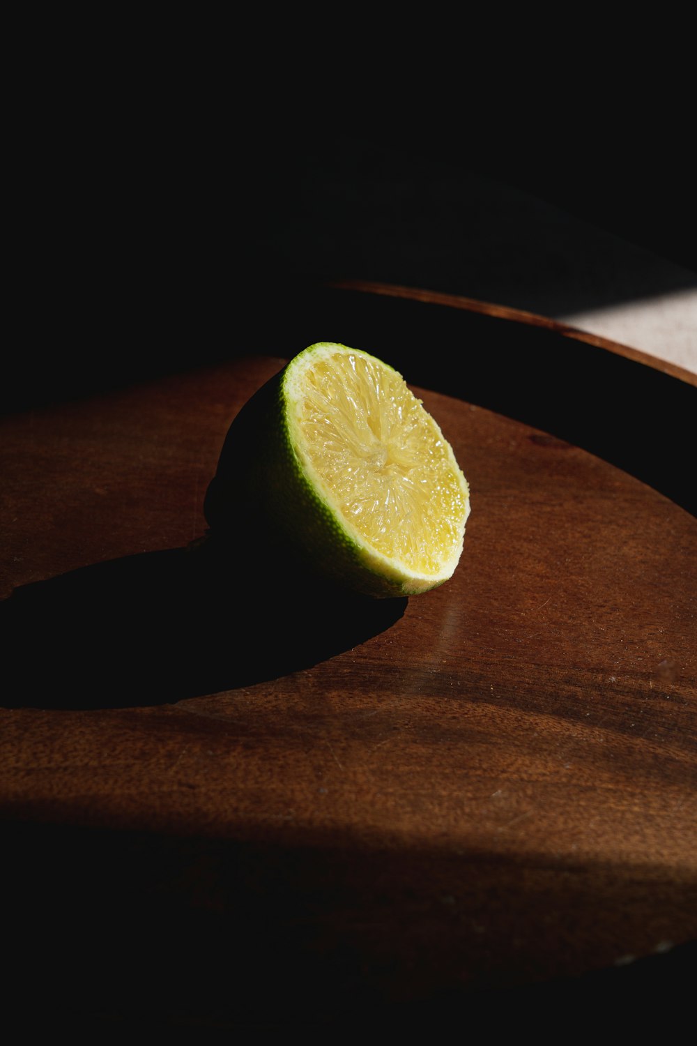 a lime sitting on top of a wooden cutting board