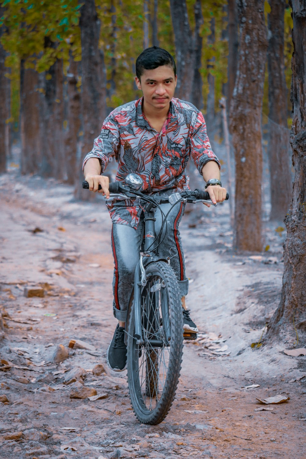 a man riding a bike through a forest