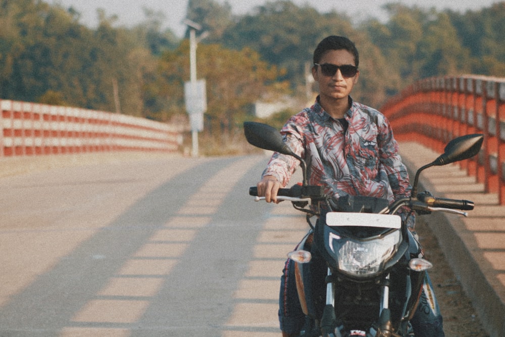 a man riding a motorcycle on a bridge