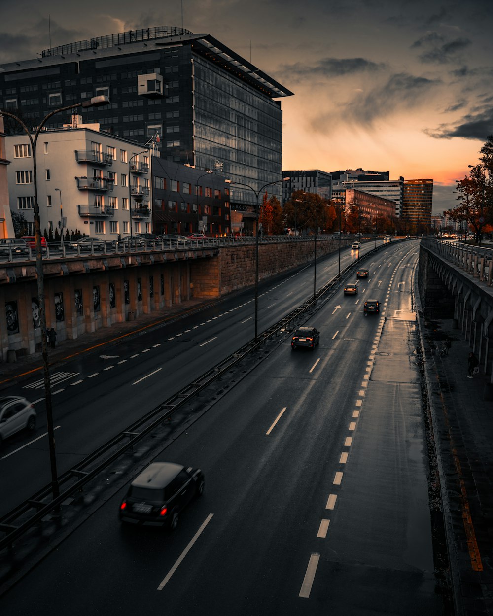 a city street filled with lots of traffic under a cloudy sky