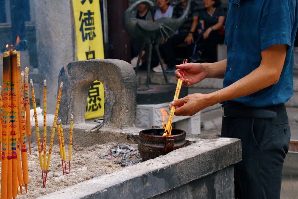 a man is lighting candles at a shrine