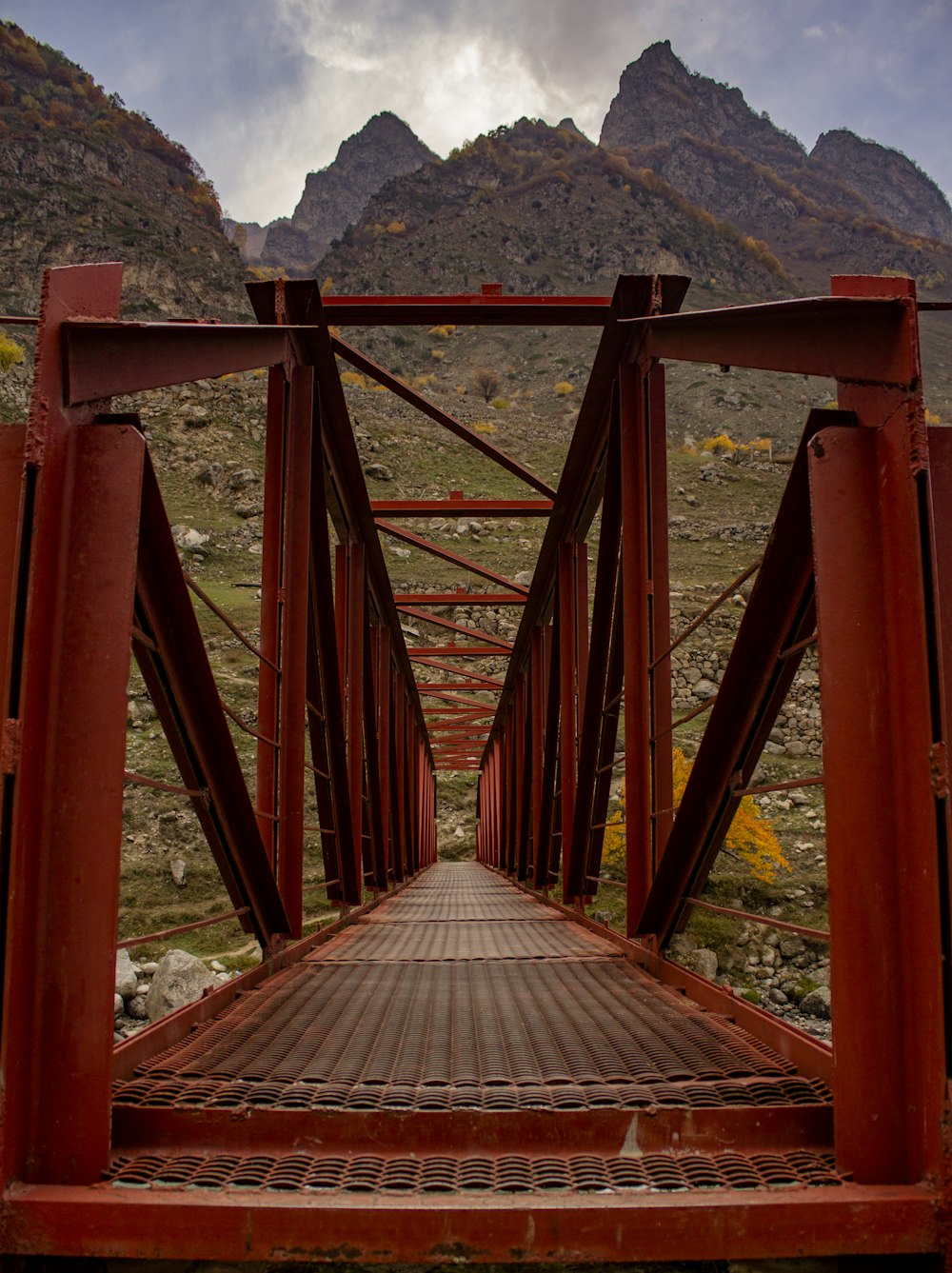 a red metal bridge with mountains in the background