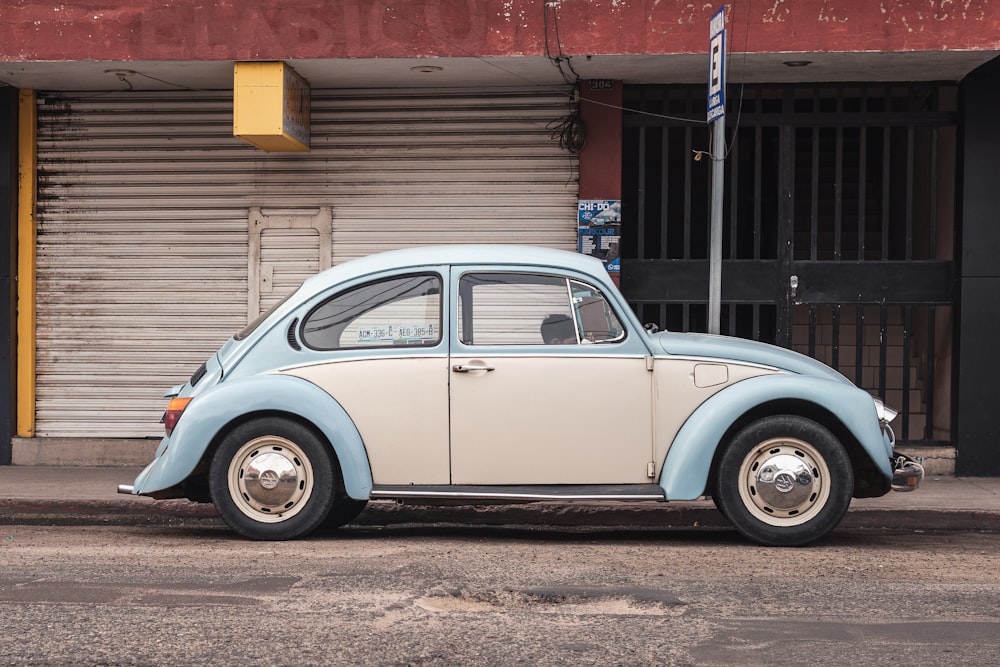 a blue and white car parked on the side of the road